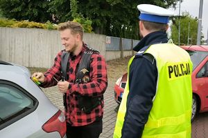 Zdjęcie przedstawia policjanta oraz motocyklistę.