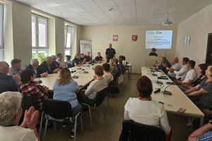 Zdjęcie przedstawia policjantów oraz uczestników debaty siedzących w sali.