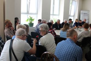 Zdjęcie przedstawia policjantów oraz uczestników debaty siedzących w sali.