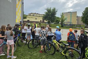 Zdjęcie przedstawia policjantów oraz dzieci z rowerami.