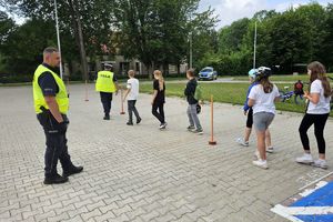 Zdjęcie przedstawia policjantów oraz dzieci na torze przeszkód.