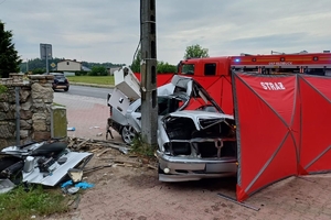 Na zdjęciu widać rozbity samochód mercedes, który uderzył w przydrożny słup oraz strażacki parawan