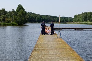 umundurowani policjanci na molo rozmawiają z grupą młodzieży