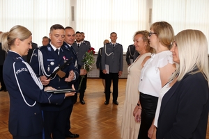 Zdjęcie przedstawia komendantów wręczających listy gratulacyjne pracownikom.