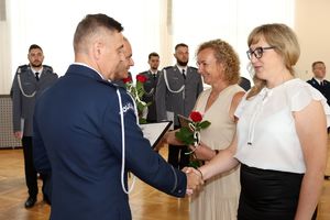 Zdjęcie przedstawia komendantów wręczających listy gratulacyjne pracownikom.