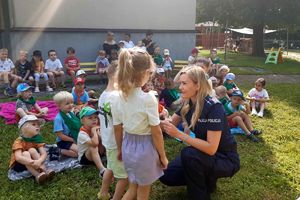 Zdjęcie przedstawia policjantkę z lizakiem oraz dzieci.