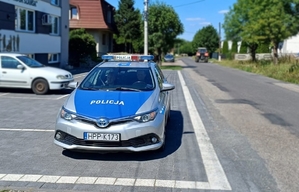 policyjny oznakowany radiowóz stoi na poboczu drogi