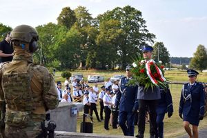 Zdjęcie przedstawia delegację kłobuckiej policji w kwiatami.