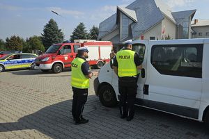 Zdjęcie przedstawia policjantów przeprowadzających kontrolę drogową.