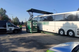 Zdjęcie przedstawia mobilną stację diagnostyczną oraz autobus.