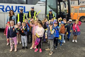 Zdjęcie przedstawia policjantów, opiekunów oraz dzieci pozujące do wspólnego zdjęcia.