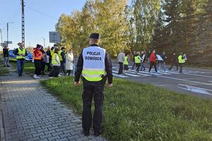 Zdjęcie przedstawia policjanta oraz protestujących.