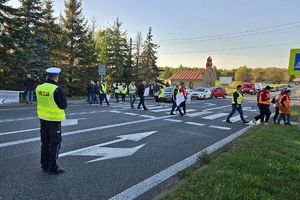 Zdjęcie przedstawia policjanta oraz protestujących.