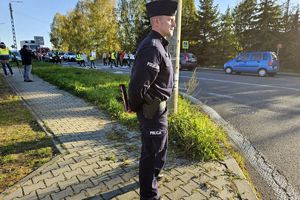 Zdjęcie przedstawia policjanta oraz protestujących.