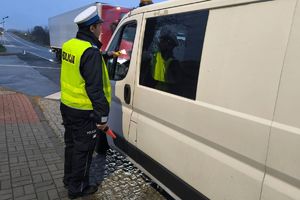 Zdjęcie przedstawia policjanta kontrolującego stan trzeźwości kierowcy.