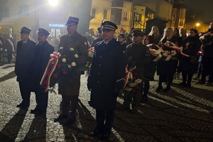 Zdjęcie przedstawia delegacje z wiązankami.