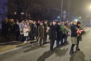 Zdjęcie przedstawia delegacje z wiązankami.