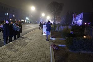 Zdjęcie przedstawia delegacje z wiązankami.