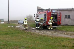 Zdjęcie przedstawia strażaków przy wozie strażackim.