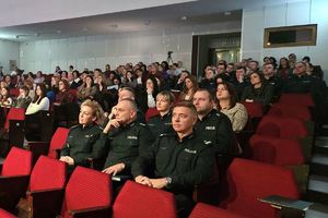 Zdjęcie przedstawia policjantów siedzących na widowni.