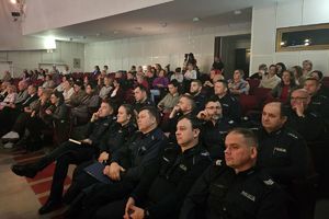 Zdjęcie przedstawia policjantów siedzących na widowni.