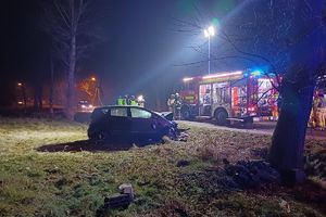 Zdjęcie przedstawia miejsce wypadku oraz strażaków i wóz strażacki.