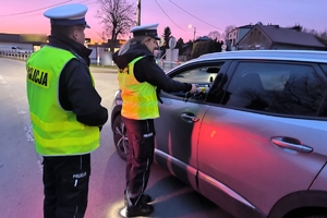 Zdjęcie przedstawia policjanta oraz policjantkę kontrolującą stan trzeźwości kierowcy.