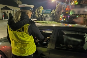 Zdjęcie przedstawia policjantkę kontrolującą stan trzeźwości kierowcy.