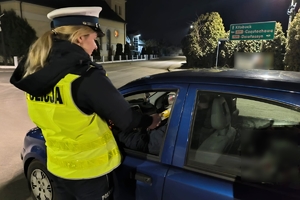 Zdjęcie przedstawia policjantkę kontrolującą stan trzeźwości kierowcy.