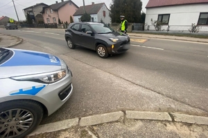 Zdjęcie przedstawia policjanta kontrolującego stan trzeźwości kierowcy.