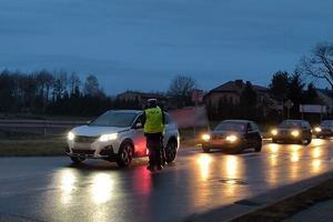 Zdjęcie przedstawia policjanta kontrolującego trzeźwość kierowcy.