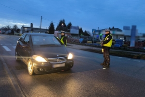 Zdjęcie przedstawia dwóch policjantów kontrolujących trzeźwość kierowcy.