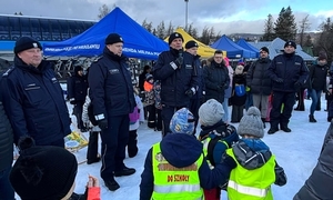 Zdjęcie przedstawia policjantów oraz narciarzy na stoku.