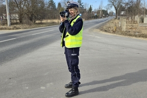 umundurowana policjantka mierzy prędkość nadjeżdżającego pojazdu