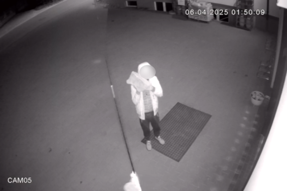 Zdjęcie przedstawia mężczyznę z cegłą na zapisie z monitoringu.