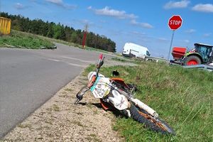 Zdjęcie przedstawia motocykl leżący na poboczu jezdni.