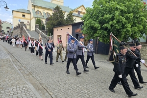 Zdjęcie przedstawia uczestników uroczystości podczas przemarszu.