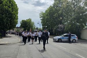 Zdjęcie przedstawia uczestników uroczystości podczas przemarszu.