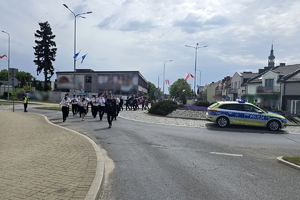 Zdjęcie przedstawia uczestników uroczystości podczas przemarszu.