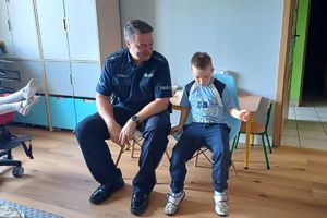 Zdjęcie przedstawia policjanta oraz chłopca.