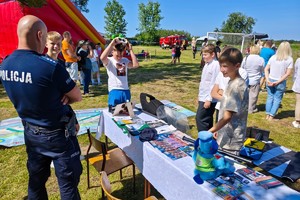 umundurowani policjanci pokazują policyjny sprzęt dzieciom