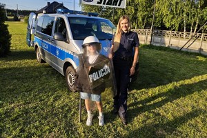 umundurowani policjanci pokazują policyjny sprzęt dzieciom