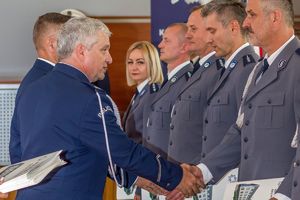 Zdjęcie przedstawia Zastępcę Komendanta Wojewódzkiego wręczającego akty mianowania policjantom.