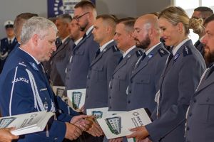Zdjęcie przedstawia Zastępcę Komendanta Wojewódzkiego wręczającego akty mianowania policjantom.