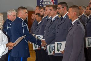 Zdjęcie przedstawia Komendanta Powiatowego wręczającego akty mianowania policjantom.
