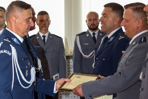 Zdjęcie przedstawia Komendanta Powiatowego wręczającego listy gratulacyjne policjantom.