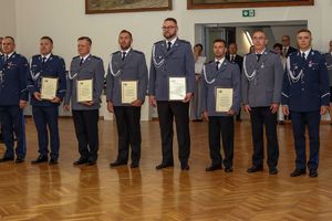 Zdjęcie przedstawia policjantów z listami gratulacyjnymi.