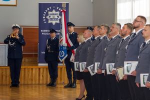 Zdjęcie przedstawia poczet sztandarowy oraz awansowanych policjantów.
