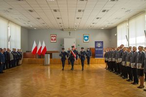 Zdjęcie przedstawia uczestników uroczystości oraz sztandar opuszczający salę sesyjną.
