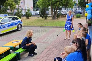 umundurowane policjantki prowadzą prelekcje z dziećmi w wieku przedszkolnym, rozdają im odblaski, pozują do zdjęcia